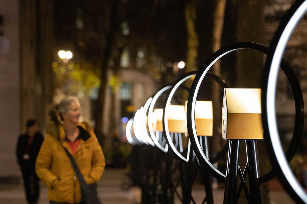 Woman admiring the VoiceLine speaker installation at night