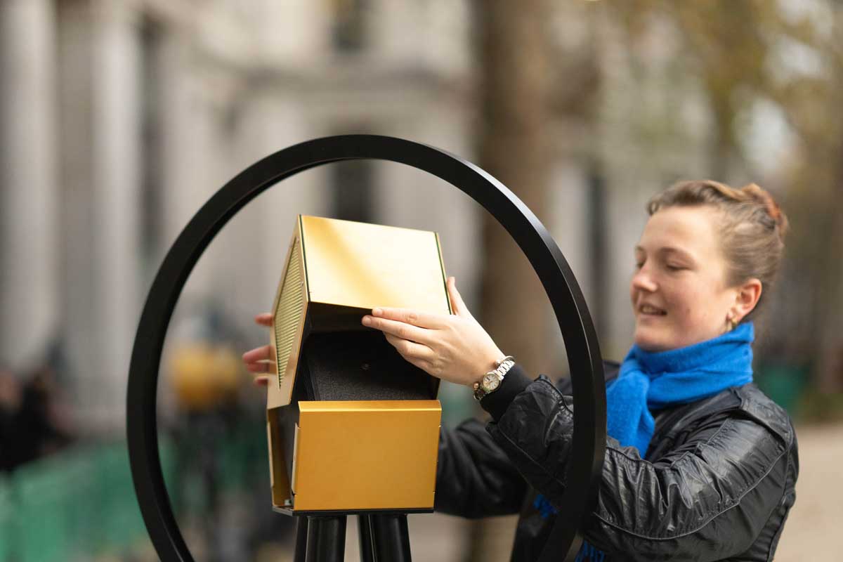 A woman installs a speaker for The VoiceLine at London's Strand