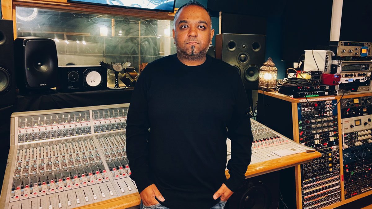 Producer and Mix Engineer Romesh Dodangoda in front of an Audient mixing console