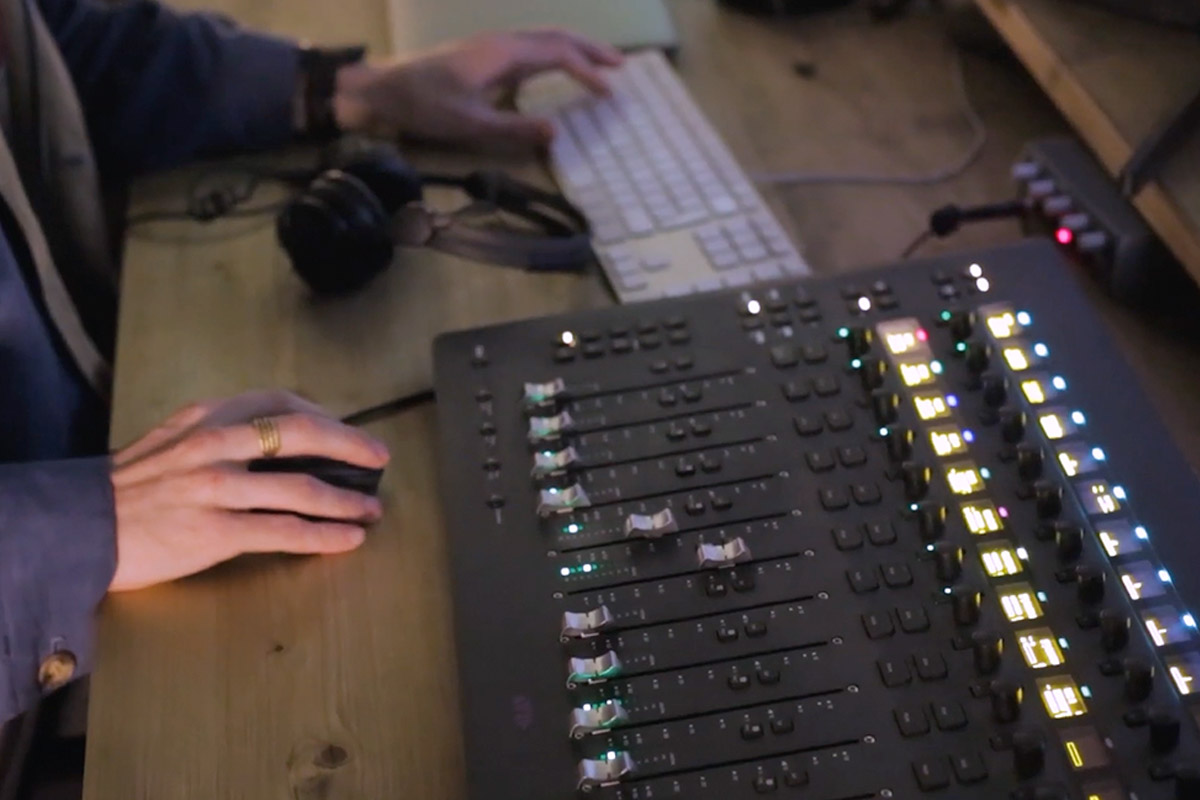 Avid S3 console and computer screens on a wooden desk