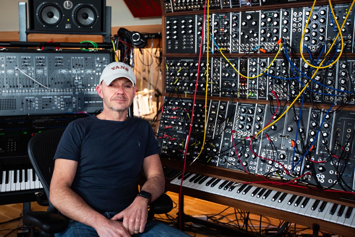 Composer Andy Gray next to his wall of Moog Modular synthesizer
