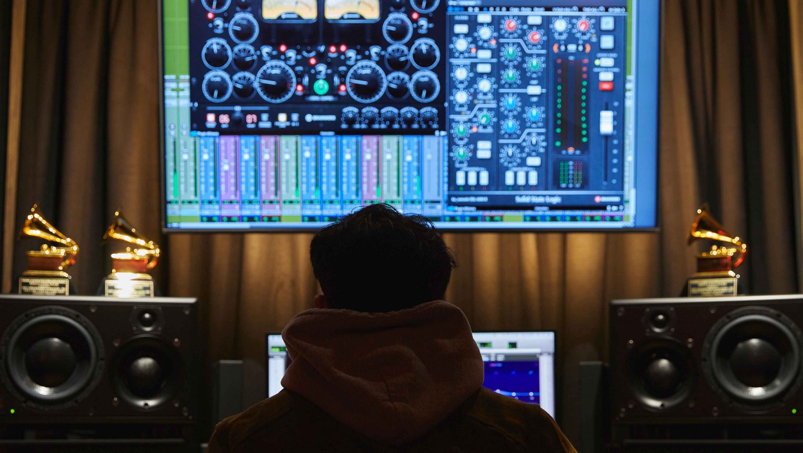 Behind shot of sound engineer Migui Maloles in front of his computer