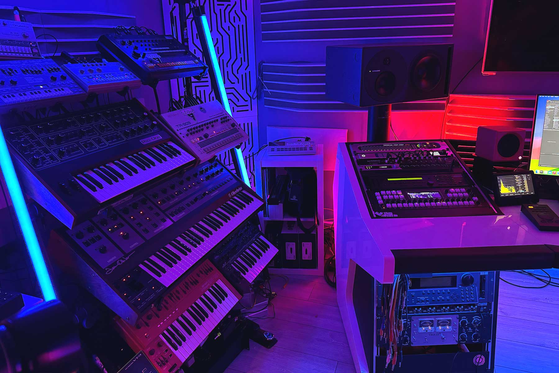 Collection of synthesizers, drum machines and a studio desk
