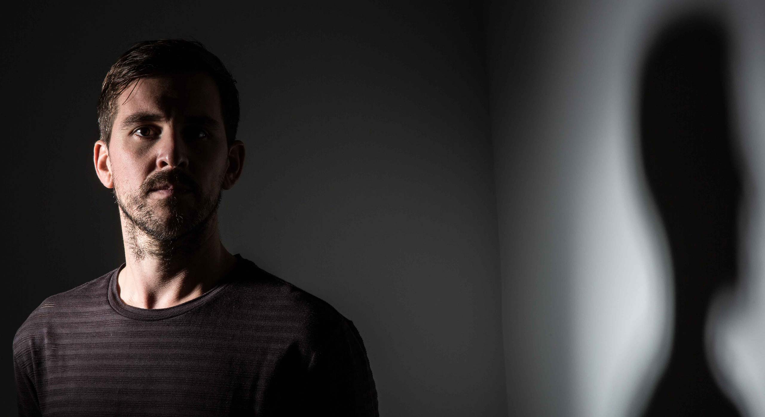 Music producer Reset Robot on a dark wall casting shadow