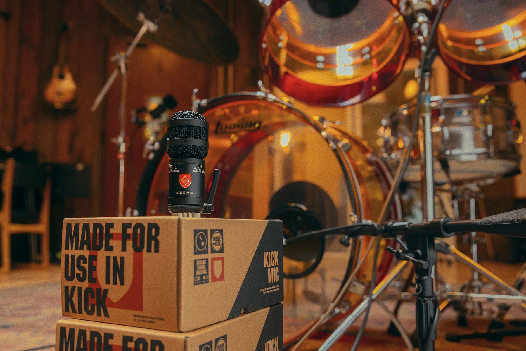 Lauten Audio Kick Mic on its box in front of a drum kit