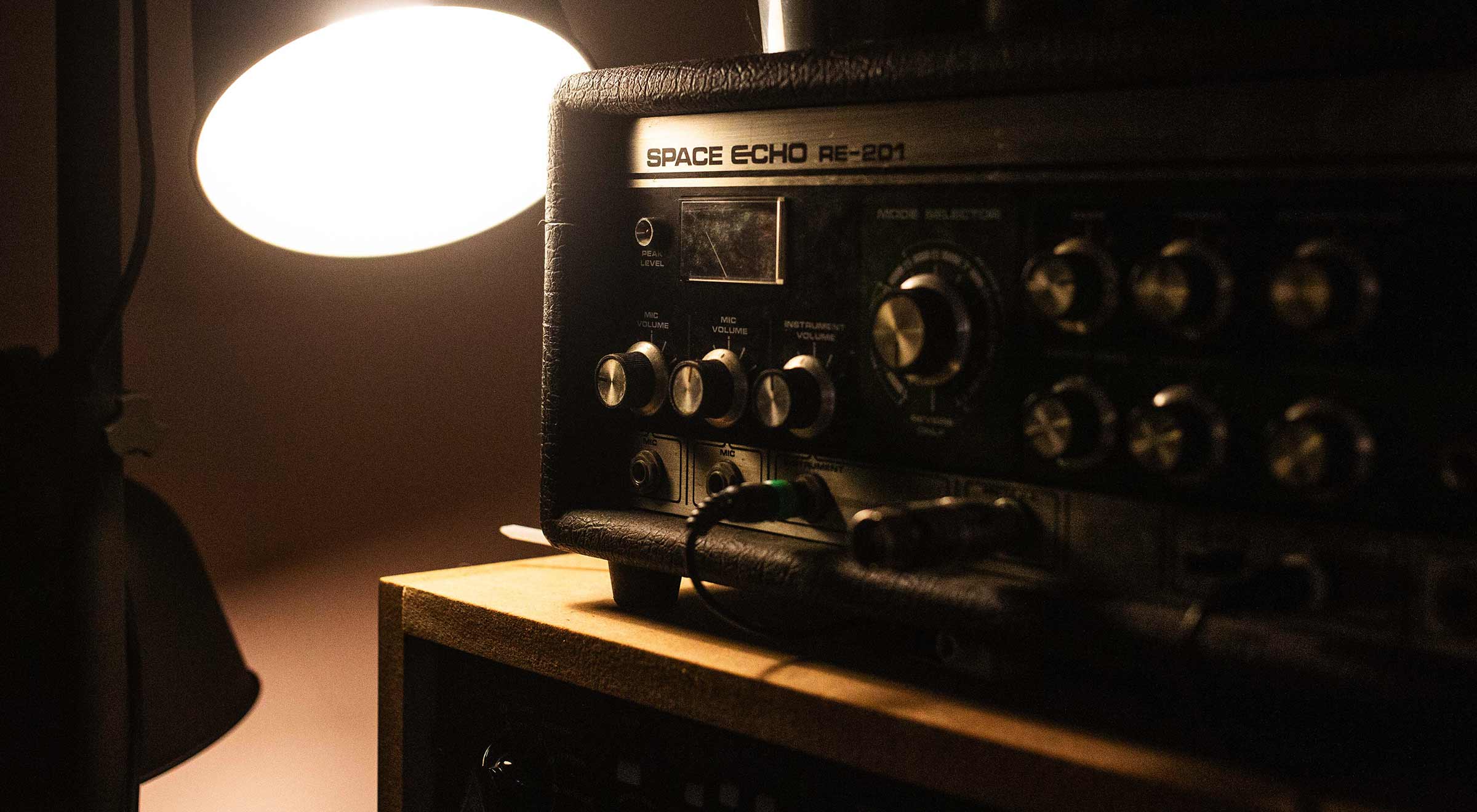 Roland Space Echo next to a desk lamp