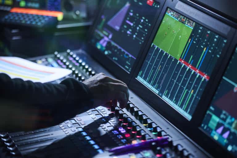 Person's hand operating Calrec Argo M console